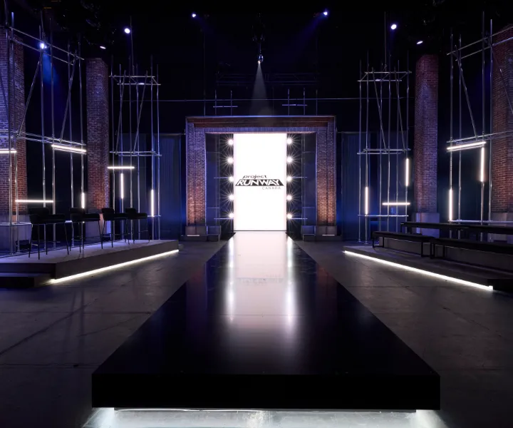 A darkened stage with scaffold towers and a glowing central screen at Chrysalis